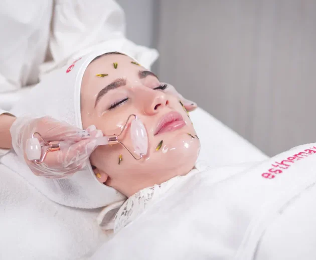 Frau erhält eine Hydrafacial Behandlung mit einem Rosenquarzroller