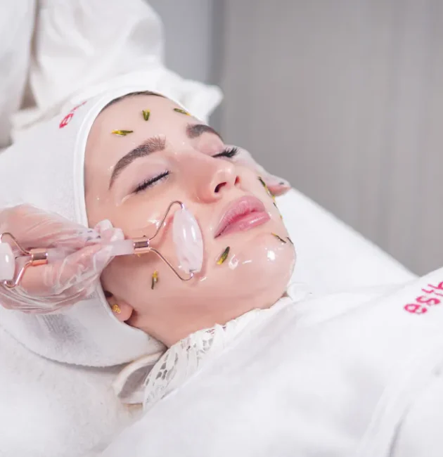 Frau erhält eine Hydrafacial Behandlung mit einem Rosenquarzroller