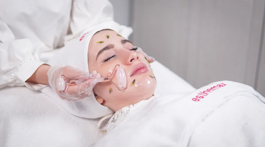 Frau erhält eine Hydrafacial Behandlung mit einem Rosenquarzroller