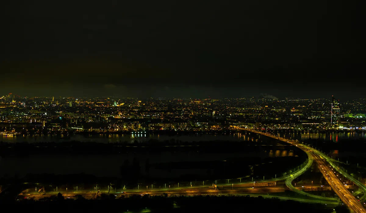 Nächtliche Ansicht von Wien mit beleuchteten Straßen und Donau