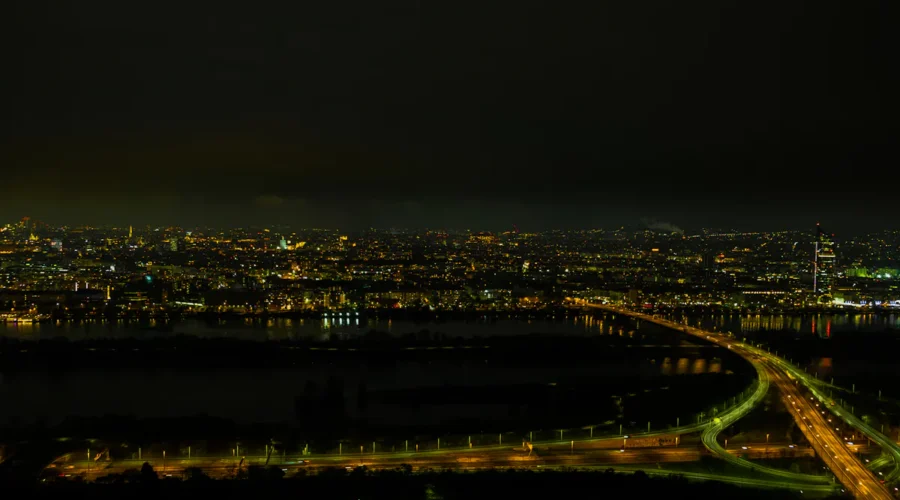Nächtliche Ansicht von Wien mit beleuchteten Straßen und Donau