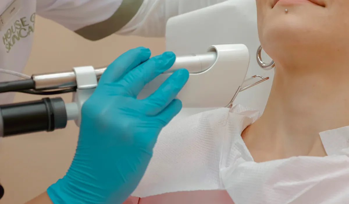 Kosmetikerin führt Hydrafacial Behandlung an Hals durch, sanfte Tiefenreinigung.