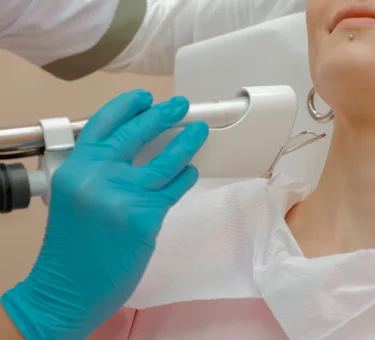 Kosmetikerin führt Hydrafacial Behandlung an Hals durch, sanfte Tiefenreinigung.