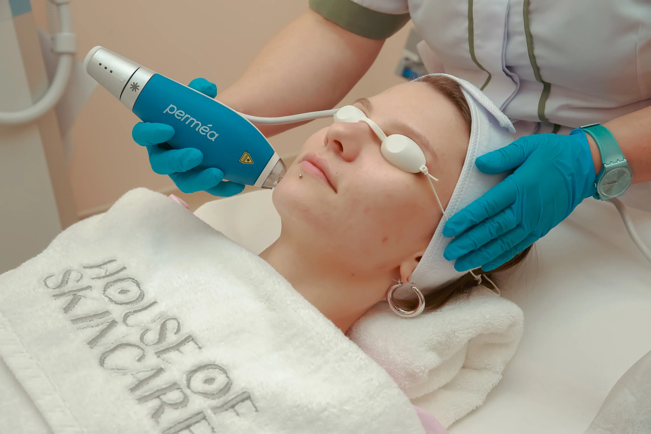 Frau unterzieht sich einer Perméa-Hydrafacial-Behandlung in einem Kosmetikstudio.