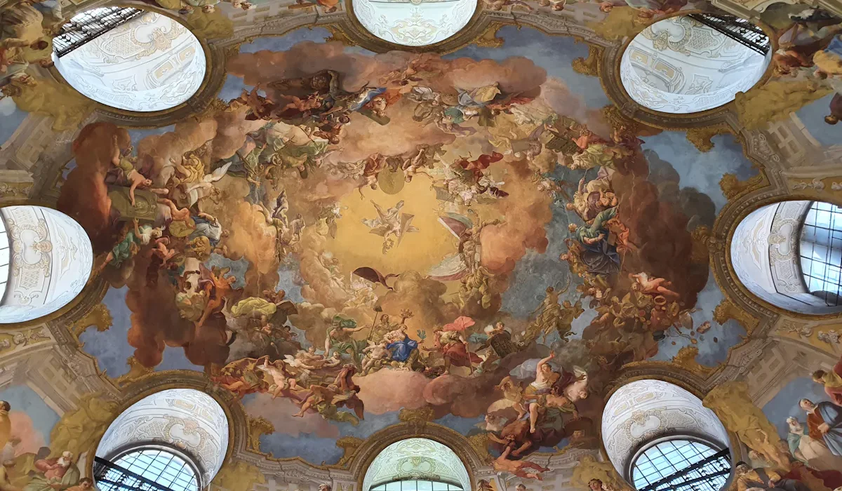 Ornate ceiling fresco with clouds and figures, Viennese architecture.