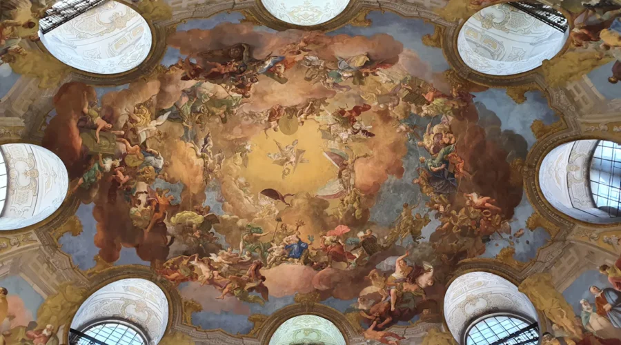 Ornate ceiling fresco with clouds and figures, Viennese architecture.