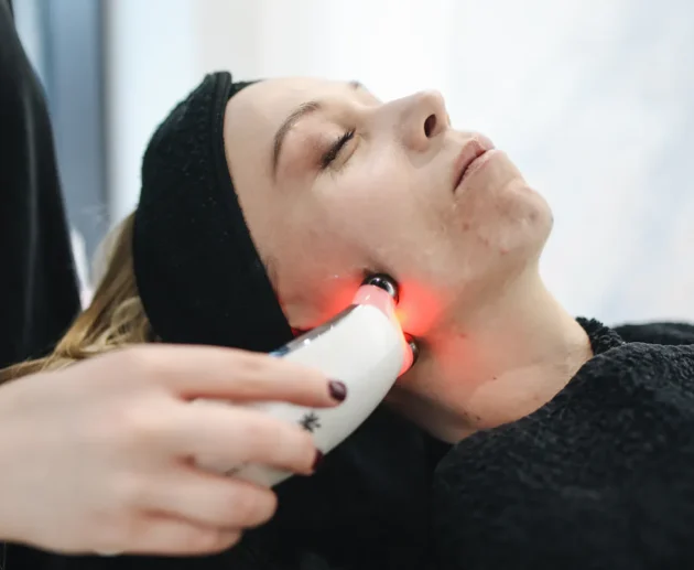 Frau erhält eine Hydrafacial Gesichtsbehandlung in Wien mit rotem LED-Licht.