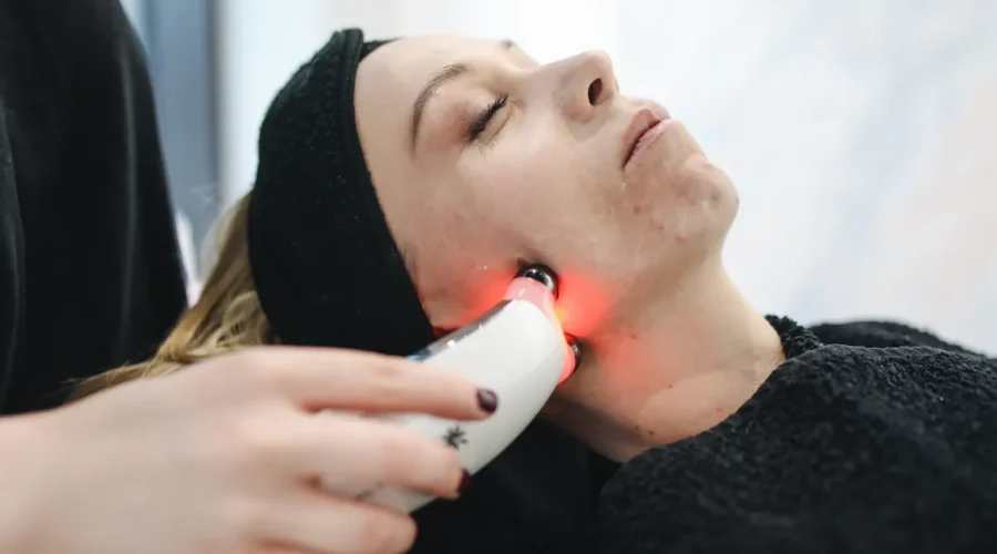 Frau erhält eine Hydrafacial Gesichtsbehandlung in Wien mit rotem LED-Licht.