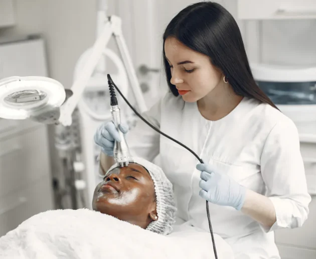 Frau erhält eine Hydrafacial Behandlung zur Gesichtsreinigung in einem Kosmetikstudio.