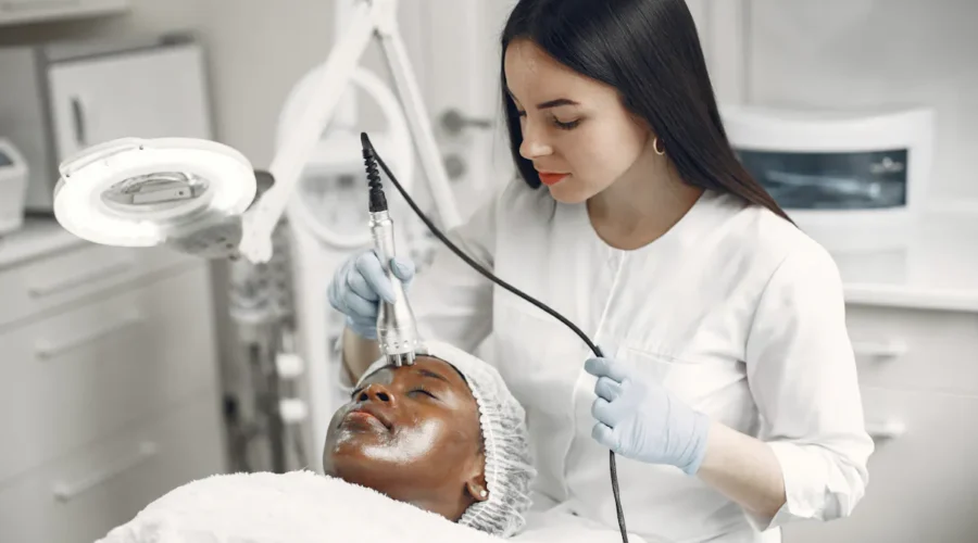 Frau erhält eine Hydrafacial Behandlung zur Gesichtsreinigung in einem Kosmetikstudio.